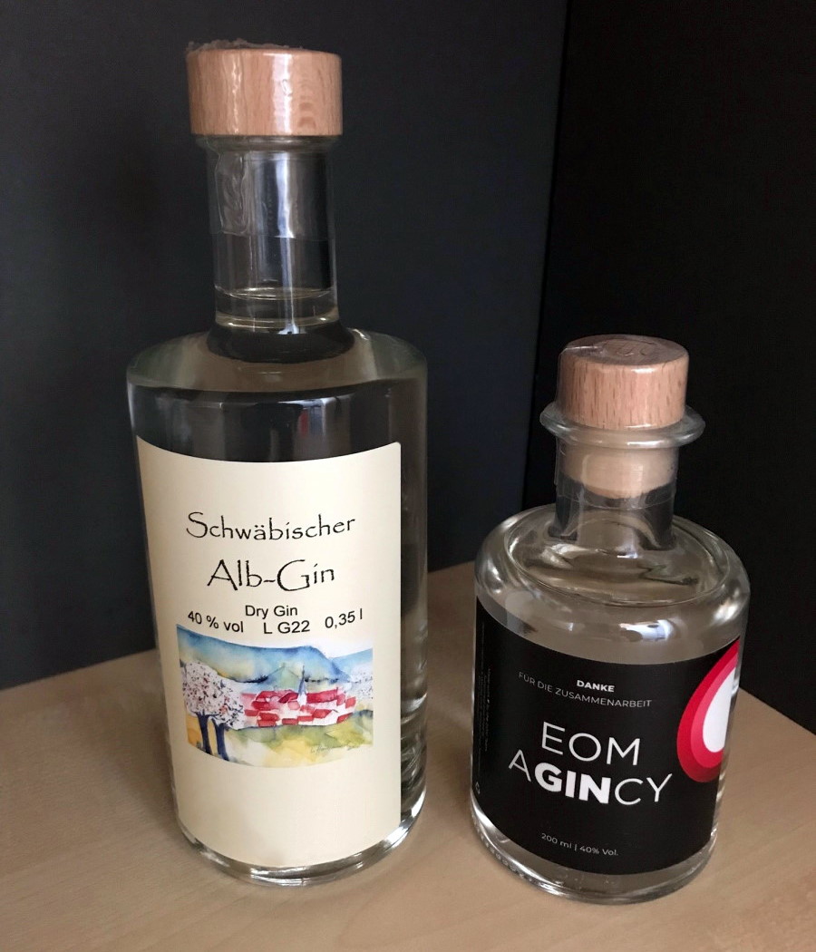 Commander des étiquettes en rouleau en impression numérique en ligne : Étiquettes de gin sur des bouteilles sur l'étagère.